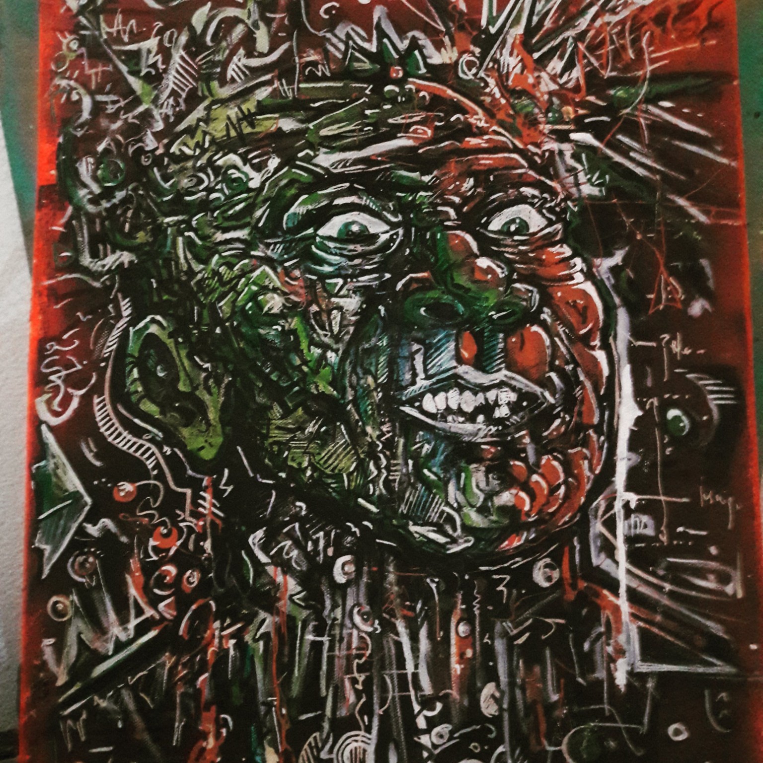 Visage organique peint en rouge, vert, blanc et noir