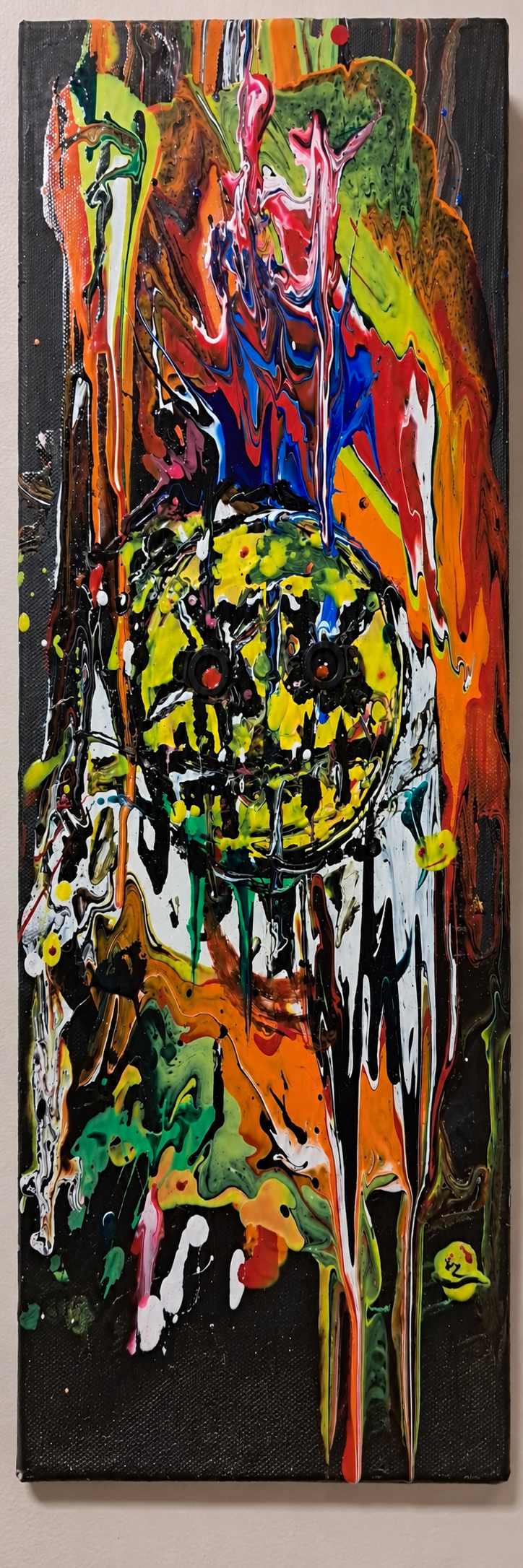Toile verticale de la série P’tits Monstres, avec visage organique jaune, yeux en éléments rapportés et coulures multicolores